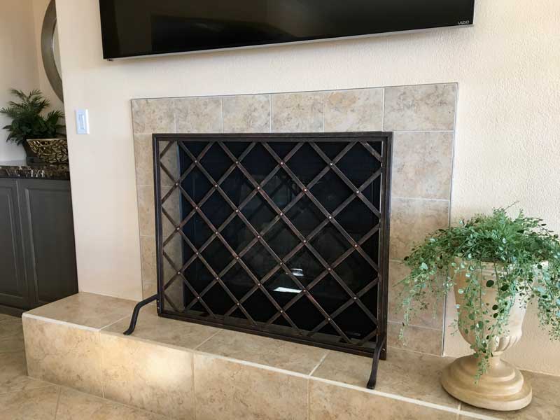 Iron Weave Single-Panel Fireplace Screen, shown in a room setting